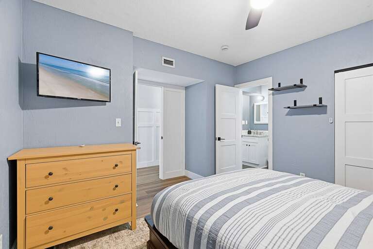 Relax during your beach stay in this peaceful bedroom featuring soft coastal tones, comfortable