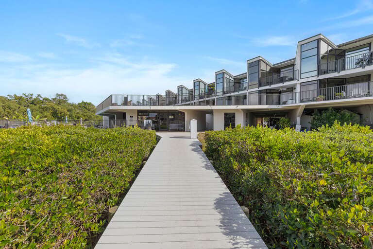 Stroll along this scenic walkway to your beach stay condo, leading to the pool, marina, and waterfront amenities. Enjoy easy access to relaxation, boating, and nearby sandy beaches.