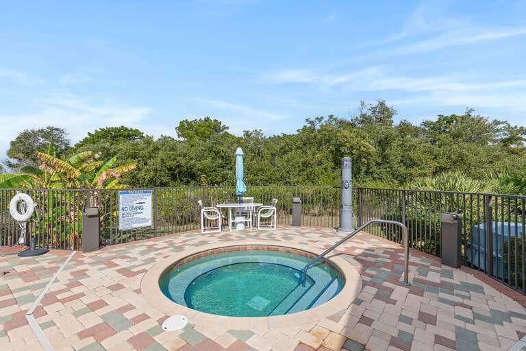 Unwind during your beach stay in this inviting hot tub oasis. Surrounded by lush greenery with seating nearby, it's the perfect spot to relax after a day at the beach or exploring the coast.