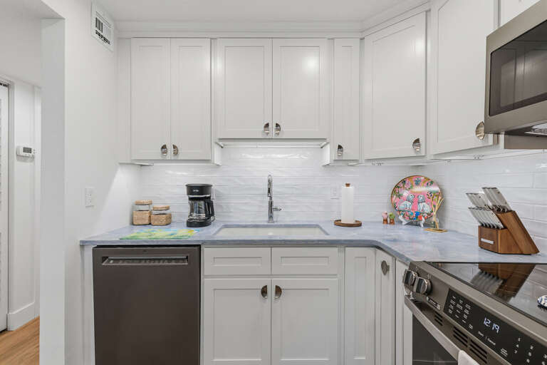This bright beach stay kitchen features modern appliances, sleek finishes, and coastal charm—perfect for preparing snacks, coffee, or family meals before heading out to the beach.