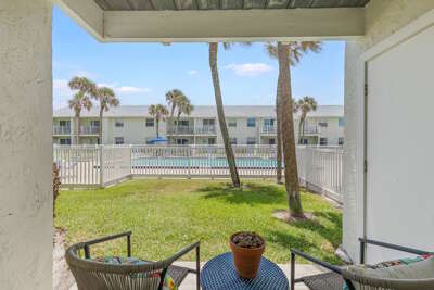 Relax on your private ground-floor patio with lush lawn views and easy access to the sparkling pool. This beach stay offers a peaceful coastal vibe, perfect for a sunny seaside getaway near the shore.