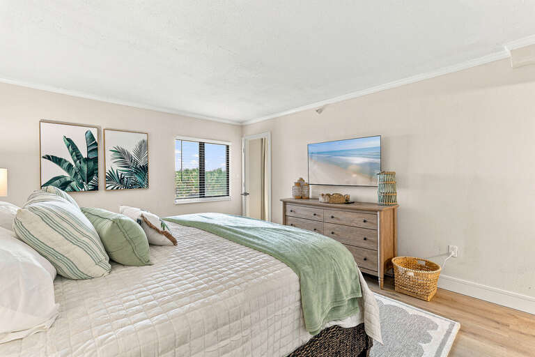 Recharge in this serene coastal king bedroom featuring soothing décor, a plush bed, and a spacious