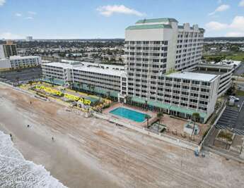 Aerial view of the oceanfront condominium complex, highlighting the beachfront setting, pool deck, spacious grounds,  Please note that portions of the beachfront area are currently under repair.