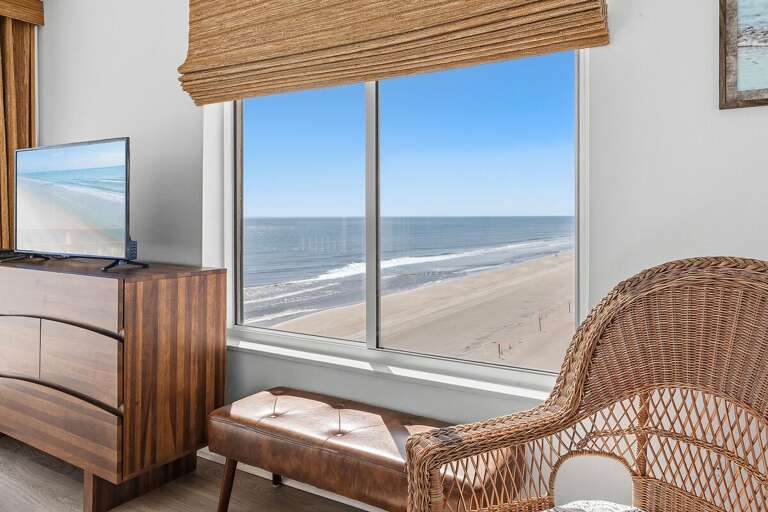 Take in sweeping ocean and sandy beach views right from the bedroom window. This peaceful coastal setting brings the beauty of the shoreline indoors, creating a relaxing backdrop for your beach stay.