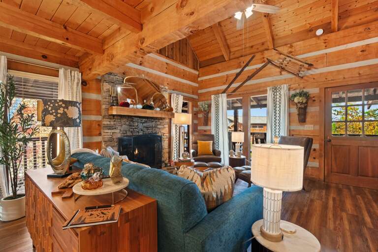 Cozy up by the stone fireplace — where warmth, modern charm, and Smoky Mountain serenity fill every moment.