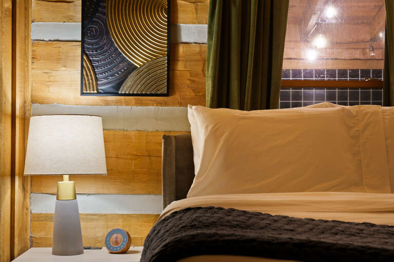 Warm tones and chic gold accents set the mood for a restful night's sleep in this inviting bedroom at Dancing Embers.