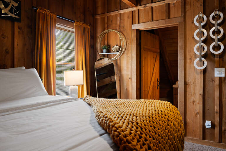 A cozy mustard throw and modern finishes give this loft bedroom serious style at Dancing Embers.
