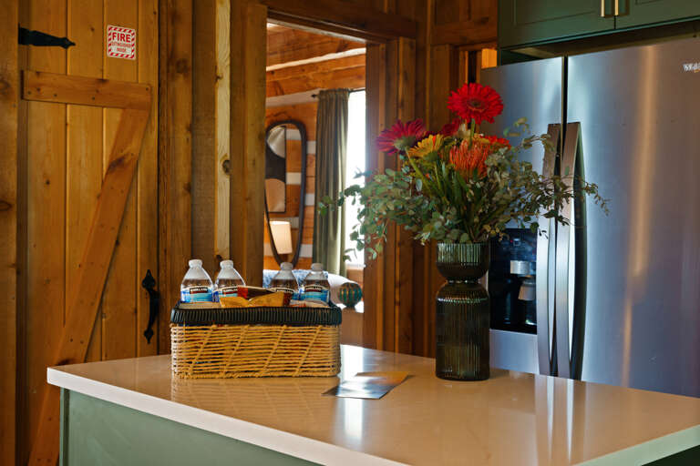 A welcome goody basket awaits on this spacious kitchen island — stocked with treats to kick off your stay at Dancing Embers.