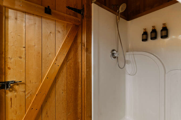A walk-in shower adds modern flair to this loft bathroom — thoughtfully designed for comfort at Dancing Embers.