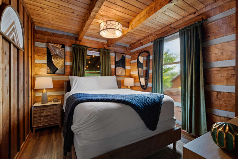 Rest easy in this stylish queen bedroom, dressed in soft navy tones and modern accents — a peaceful retreat at Dancing Embers.