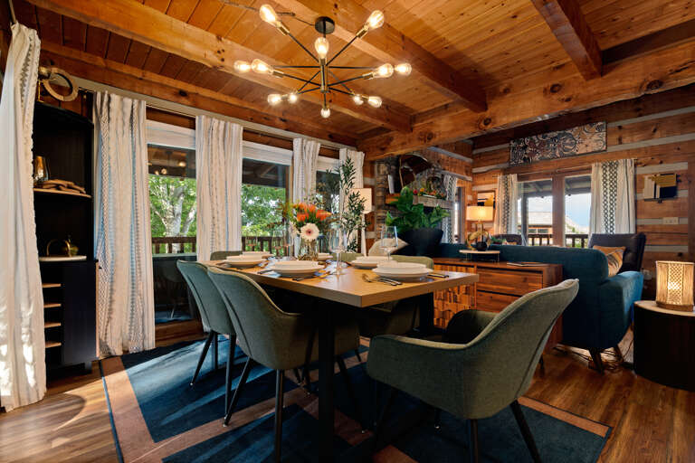 Candlelit dinners feel extra special at this stylish dining table, framed by soft curtains and mountain views at Dancing Embers.