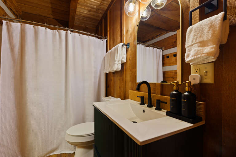 Fresh towels and a spacious shower make getting ready a breeze in this sleek, modern bathroom at Dancing Embers.