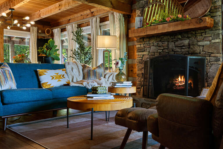 Curl up by the sleek stone fireplace — the living room at Dancing Embers is the coziest seat in the Smoky Mountains.