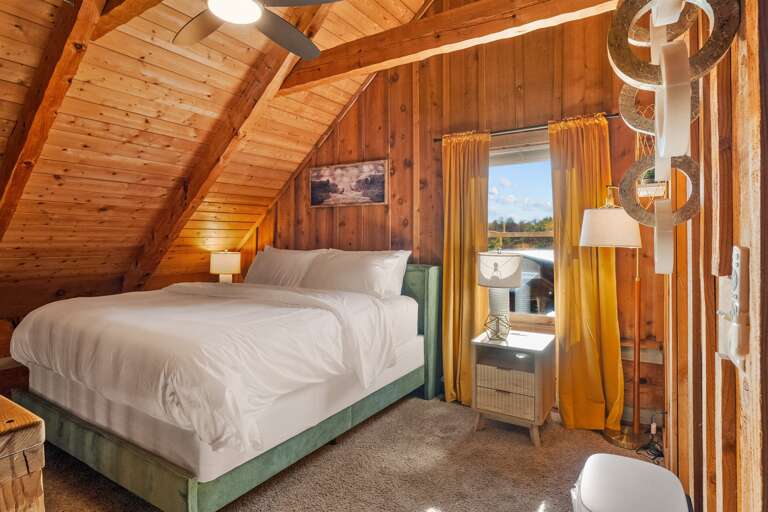 Dream under the beams — cozy lighting, modern charm, and the warmth of a true Smoky Mountain cabin.