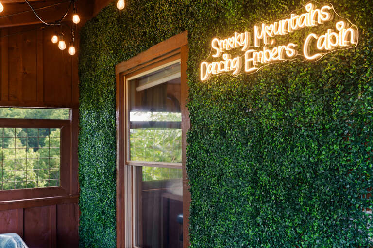 Relax under the warm glow of the Dancing Embers sign — a signature touch that makes every soak feel like a getaway.