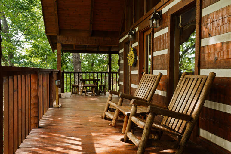 Rock the day away on the private deck at Nestled Oaks, surrounded by peaceful, wooded Smoky Mountain scenery.