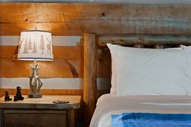 Rest easy in the queen bed at Nestled Oaks, where handcrafted log furnishings bring true Smoky Mountain charm.