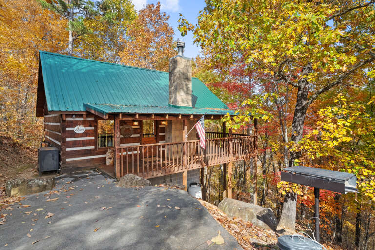 Tucked into the trees: Your log cabin retreat, tucked among the trees.  Fall color, a wraparound porch, and a stone chimney waiting for you.