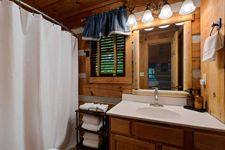 Fresh towels and rustic charm come together in the well-appointed bathroom at Nestled Oaks.