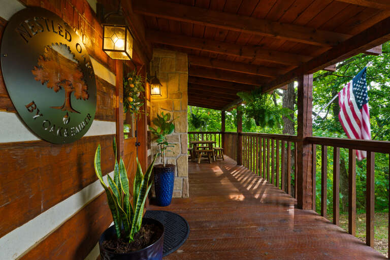 Wrapped in wooded views, the covered porch at Nestled Oaks is the perfect place to slow down and breathe in the mountain air.