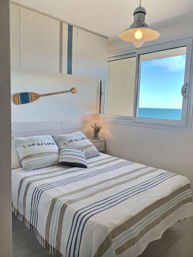 Bed Beside Big Bright Window With Ocean View