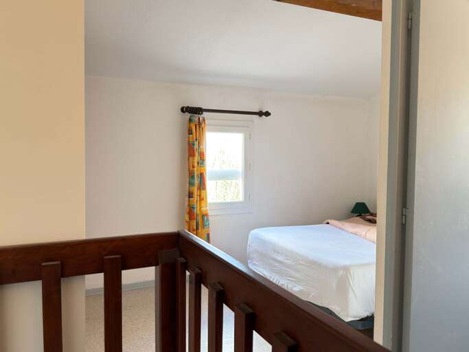 Simple Room With Bed, Bright Window, And Wooden Railing