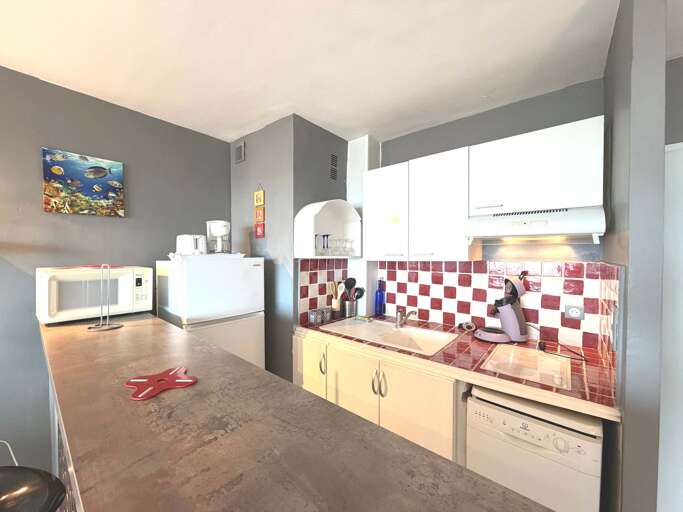 Kitchen Corner With Checkered Backsplash, Countertop, And Microwave