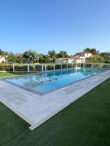 Glistening Pool With Lush Greenery In A Serene Setting