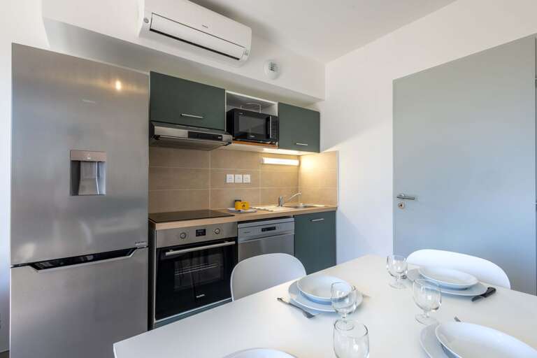 Compact Kitchen Corner With Sleek Steel Surfaces, Set Table