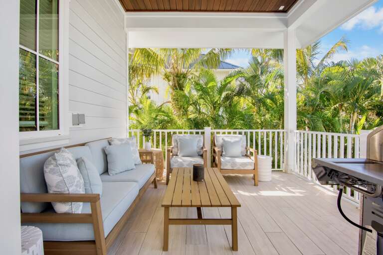 Private covered terrace with comfortable seating and a BBQ grill