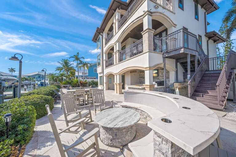 Multiple balconies, palm trees, and outdoor entertaining spaces.