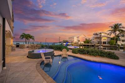 Waterfront pool, hot tub, and breathtaking sunset views over tropical waters.