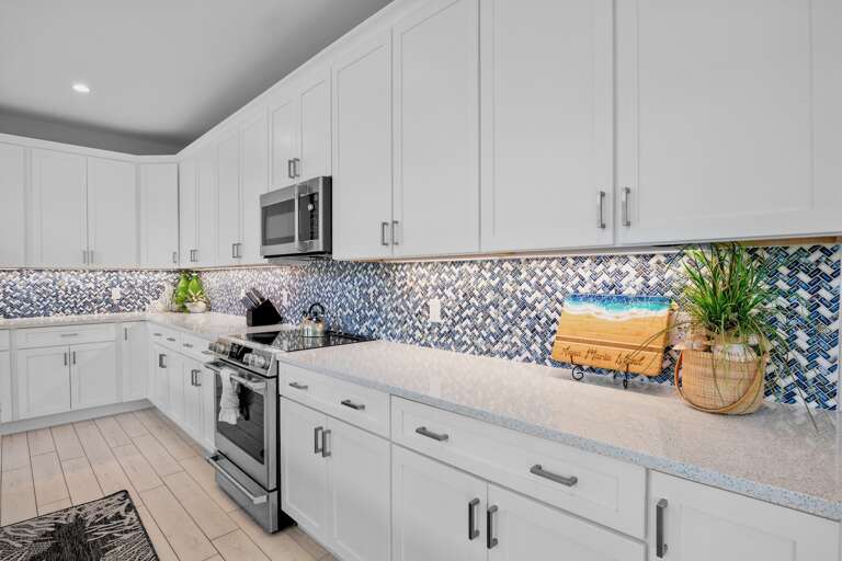 Fully equipped kitchen features white cabinets