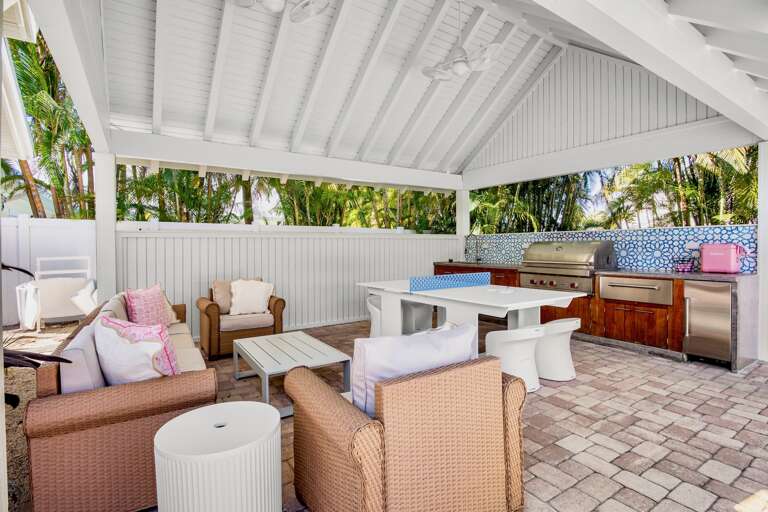 Covered outdoor lounge, grill, and ping pong table to challenge family and friends