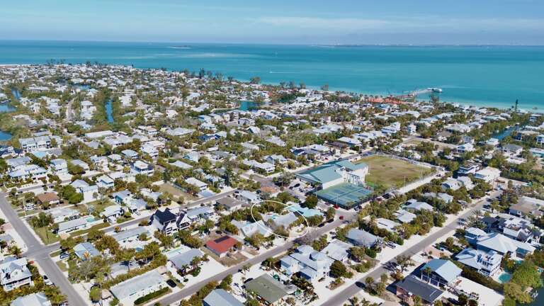 Aerial view of a charming coastal community with pristine turquoise waters and sandy beaches nearby.