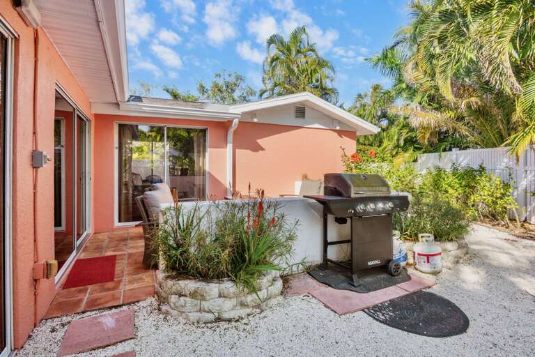 BBQ grill surrounded by lush palms