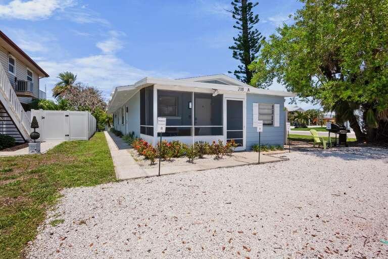 Exterior view of the home with screened lanai and dedicated parking.