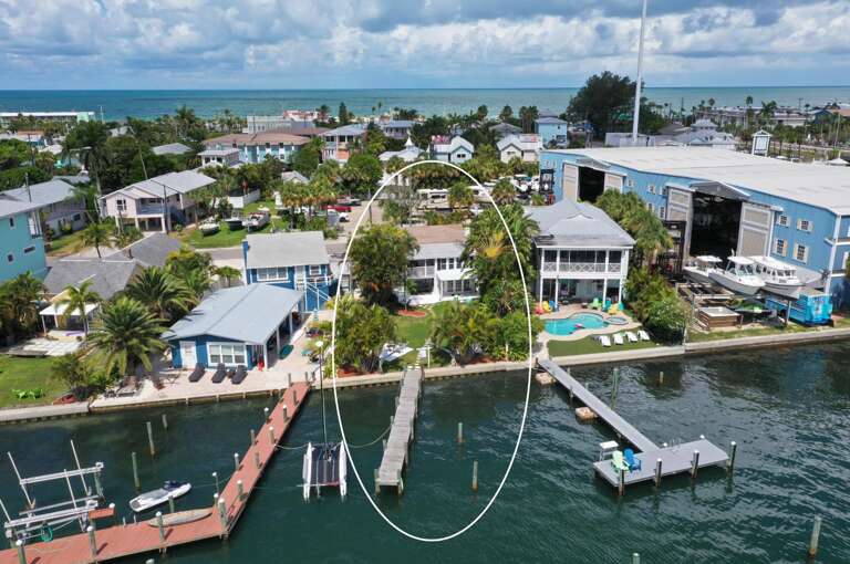 Waterfront property with private dock and pool situated on calm turquoise waters in charming coastal neighborhood.