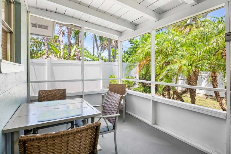 Screened-in lanai with outdoor dining table.