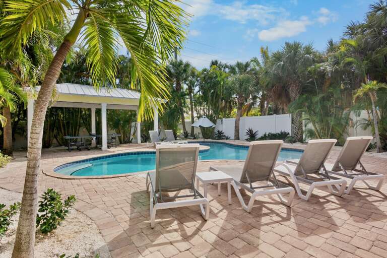 Private tropical oasis surrounded by lounge chairs