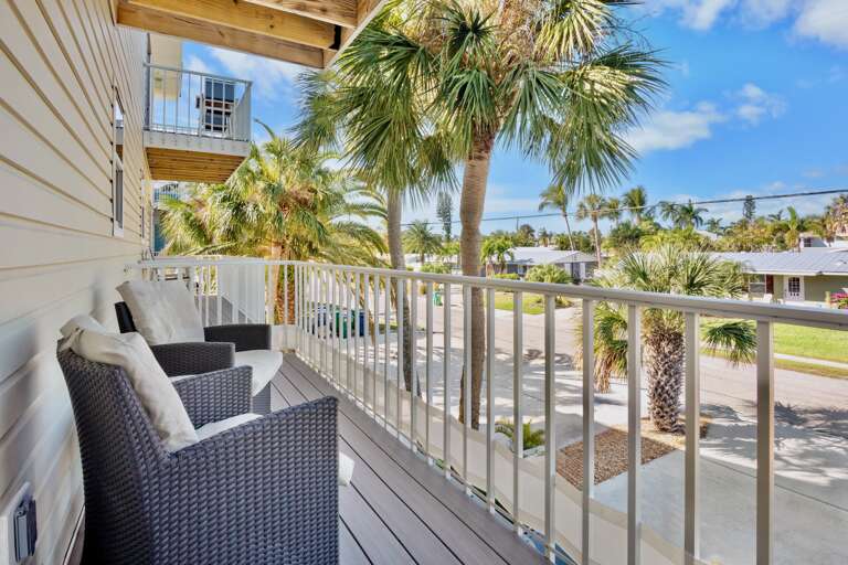 Your private balcony offers comfortable seating and tropical palm views, perfect for morning coffee or sunset relaxation.
