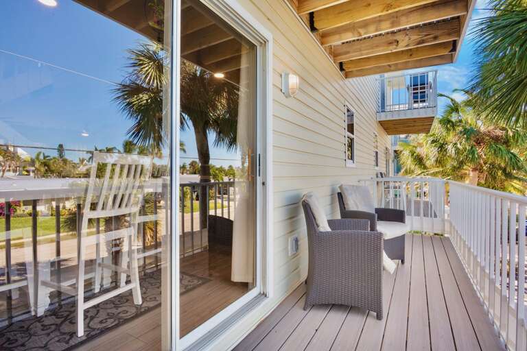 Step onto your private balcony with wicker seating where tropical breezes and swaying palms create the perfect spot for morning coffee or sunset relaxation.