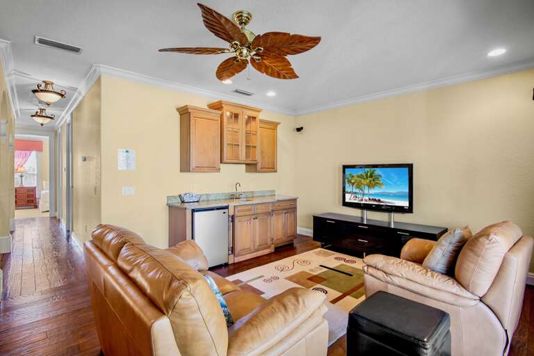 Second living room area with plush seating, kitchenette, and TV