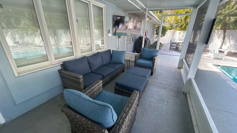 Relax in your private screened patio where comfortable seating awaits you to unwind while overlooking the pool and lush surroundings.