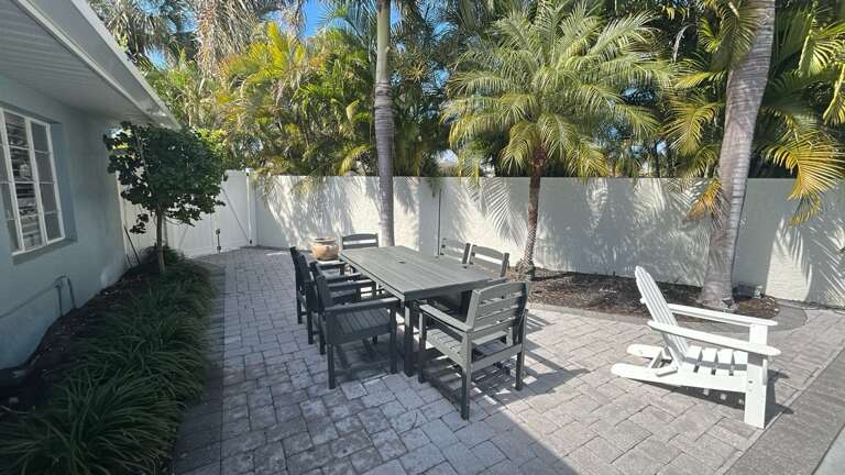 Your private outdoor oasis features tropical palms, spacious dining for six, and cozy lounge chairs—perfect for morning coffee or evening gatherings.