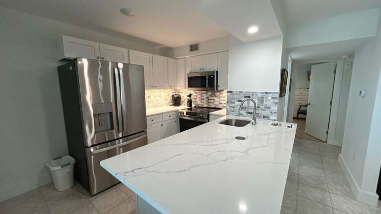 Cook your favorite meals in this stunning modern kitchen featuring granite countertops, stainless steel appliances, and ample prep space.