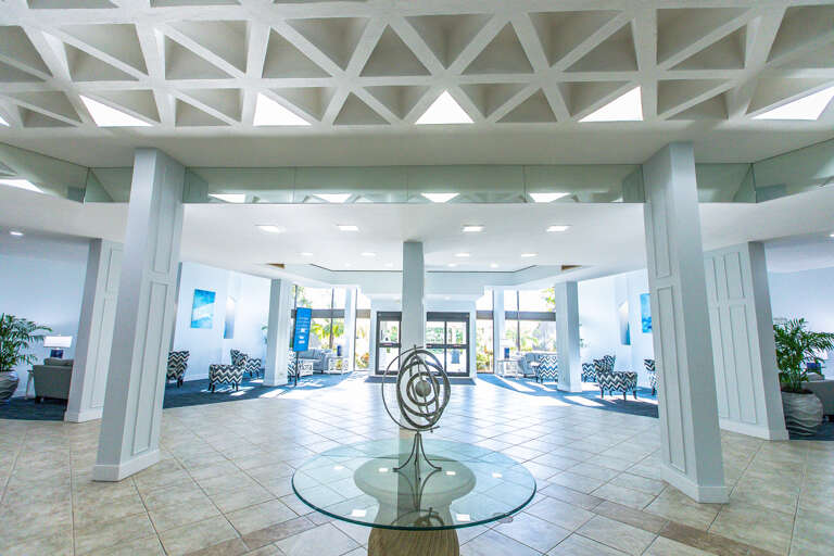 Step into an elegant lobby with striking geometric ceiling details, modern art, and comfortable seating areas that welcome you home.