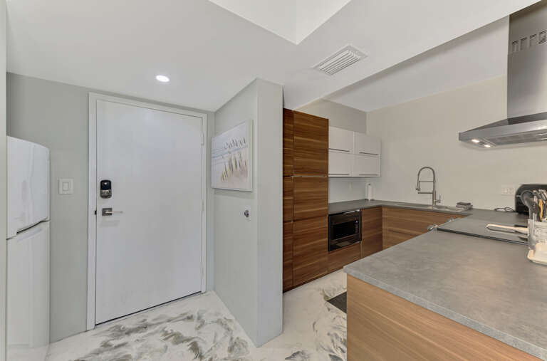 Your sleek kitchen features wood-grain cabinets and stone countertops, perfect for preparing meals in style.