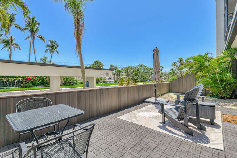 Your private patio offers comfortable outdoor dining and lounging with tropical palm views under sunny Florida skies.