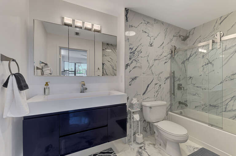 Indulge in your luxurious marble-wrapped bathroom, where elegant veining creates a spa-like retreat for your morning and evening routines.